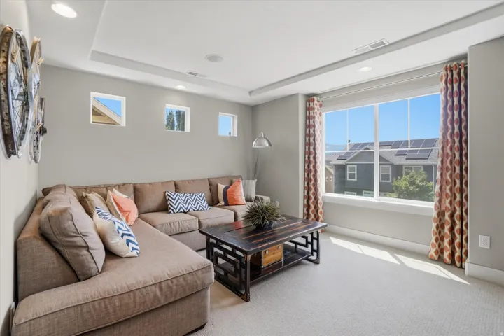 Carpeted living space featuring recessed lighting and a tray ceiling