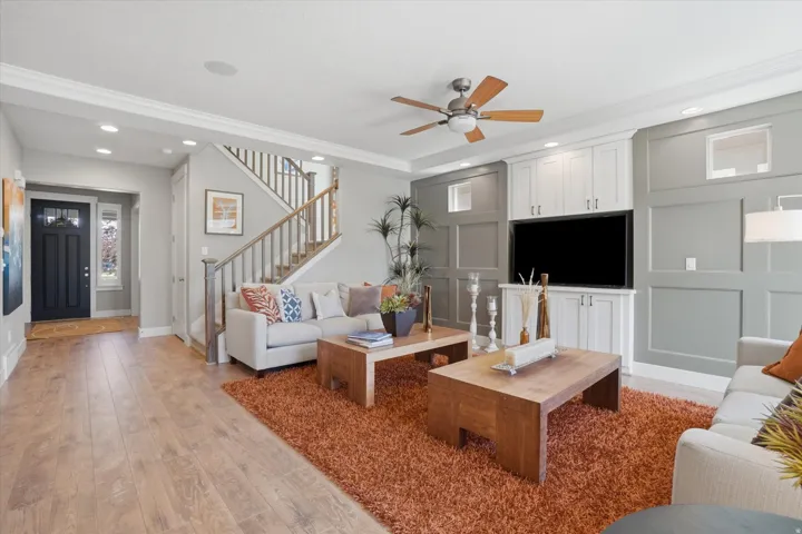 Open-concept living space featuring wood-finish flooring and a built-in media center with paneling