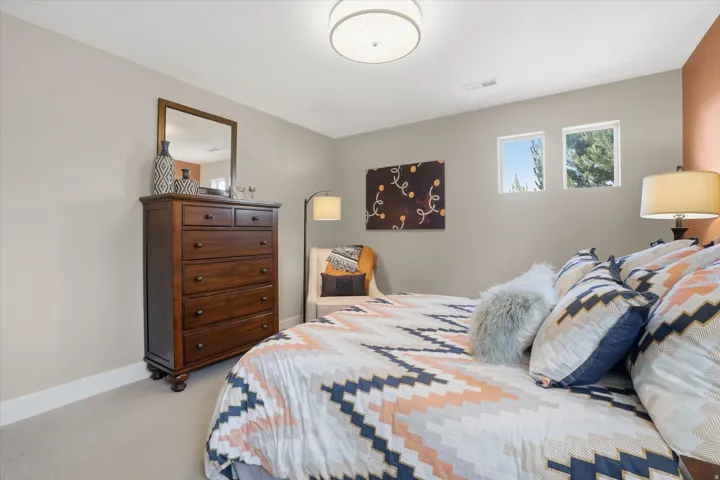 Bedroom featuring two transom windows, light neutral wall paint, and a modern flush-mount ceiling light fixture