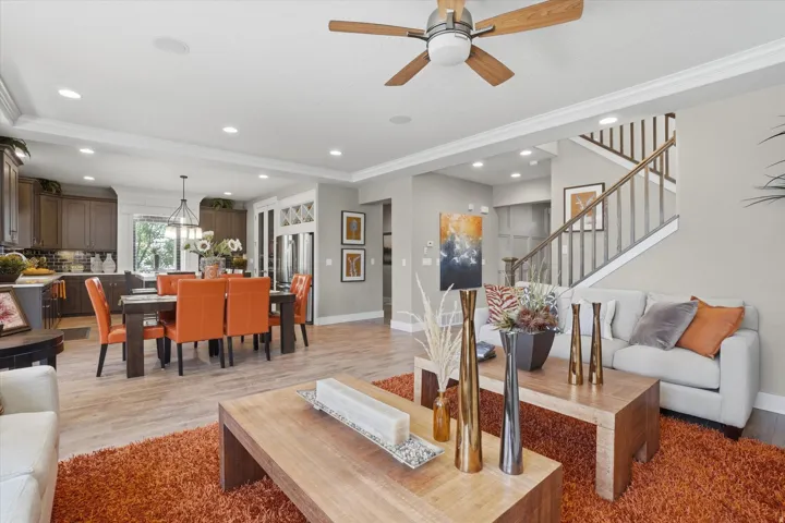 Open-concept living area with wood-finish flooring, recessed lighting, and a ceiling fan