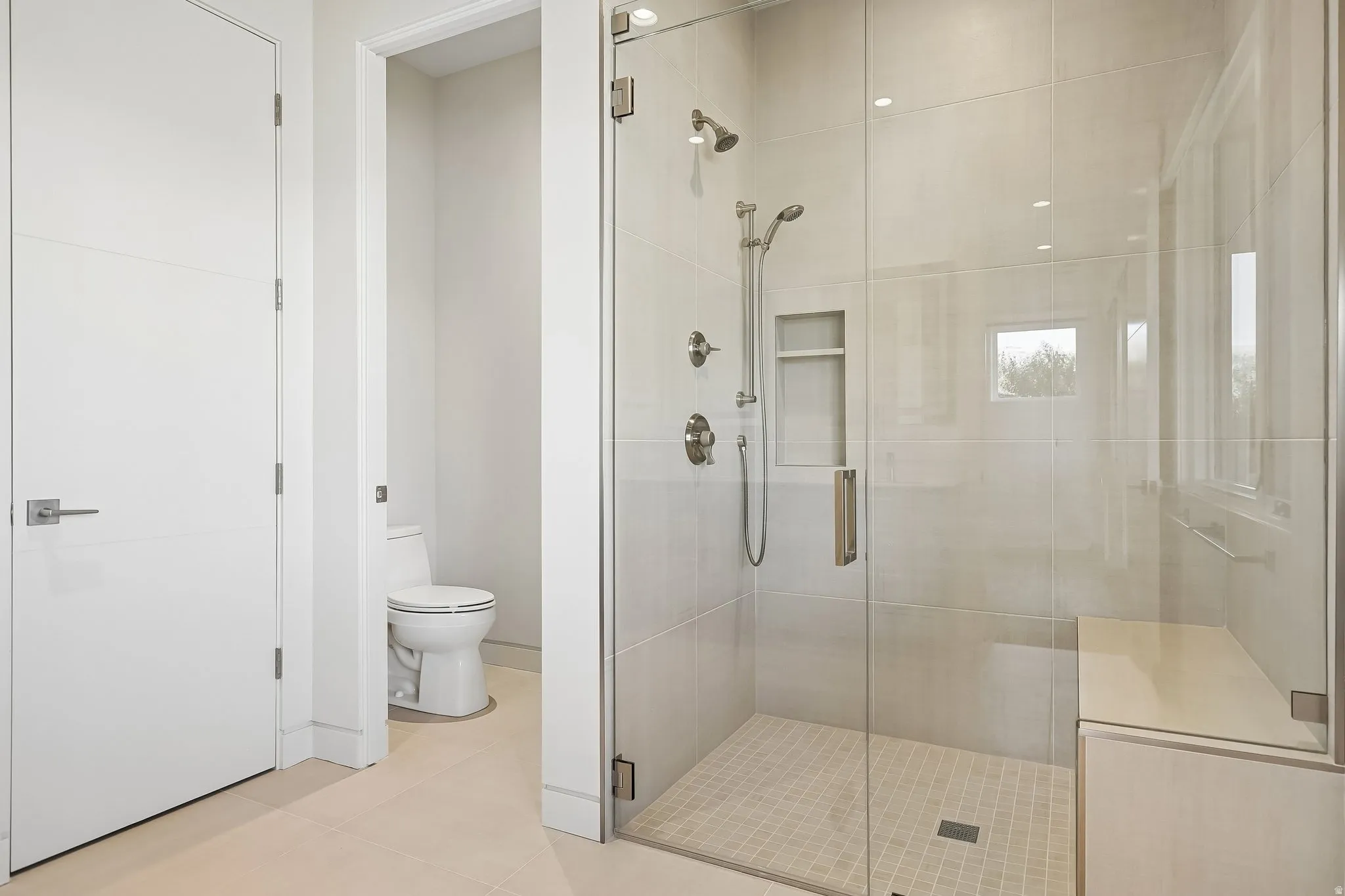 Spacious walk-in shower with clear glass enclosure and a built-in bench