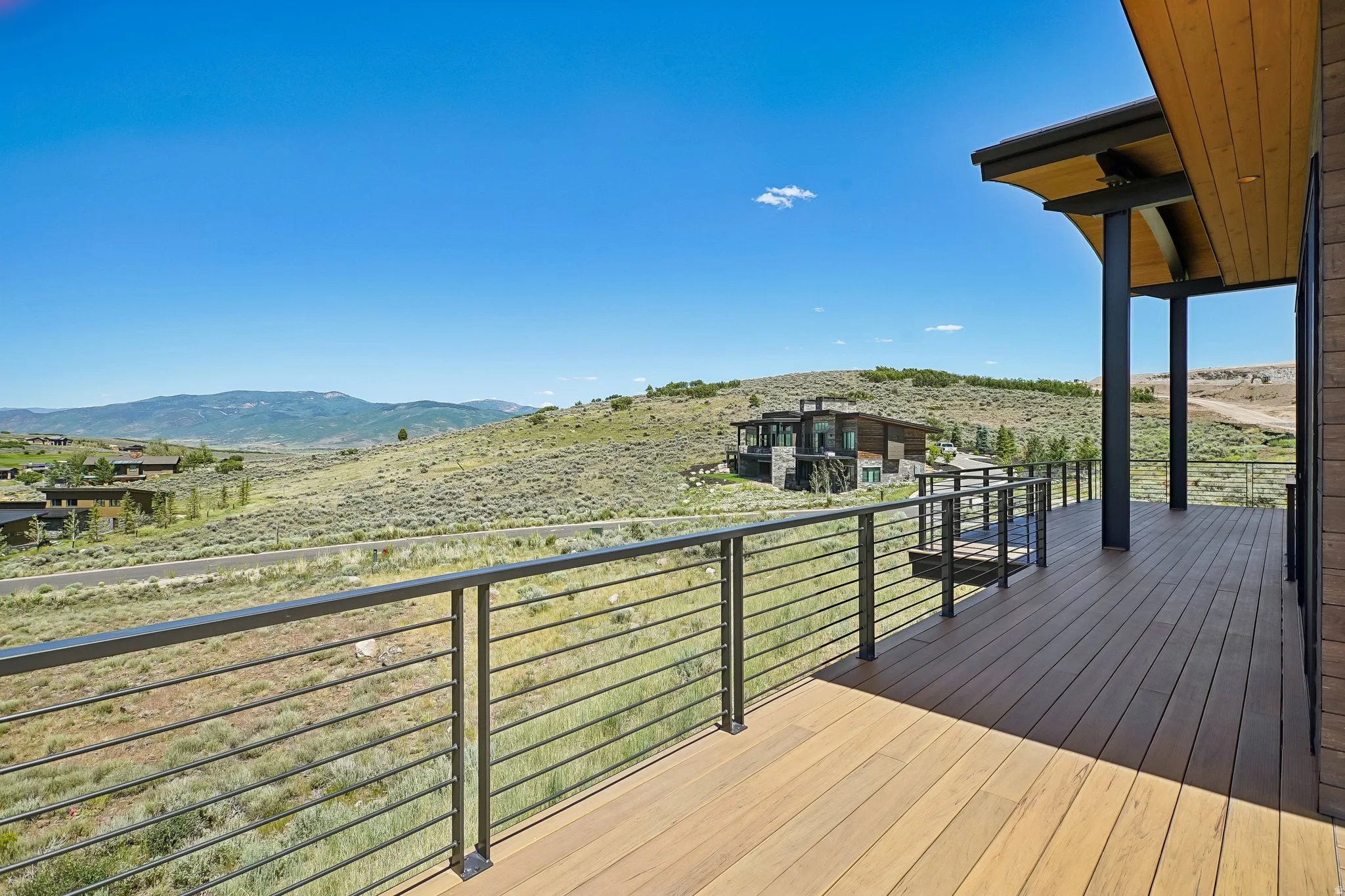 Expansive outdoor deck featuring wood-finish decking and contemporary cable railings