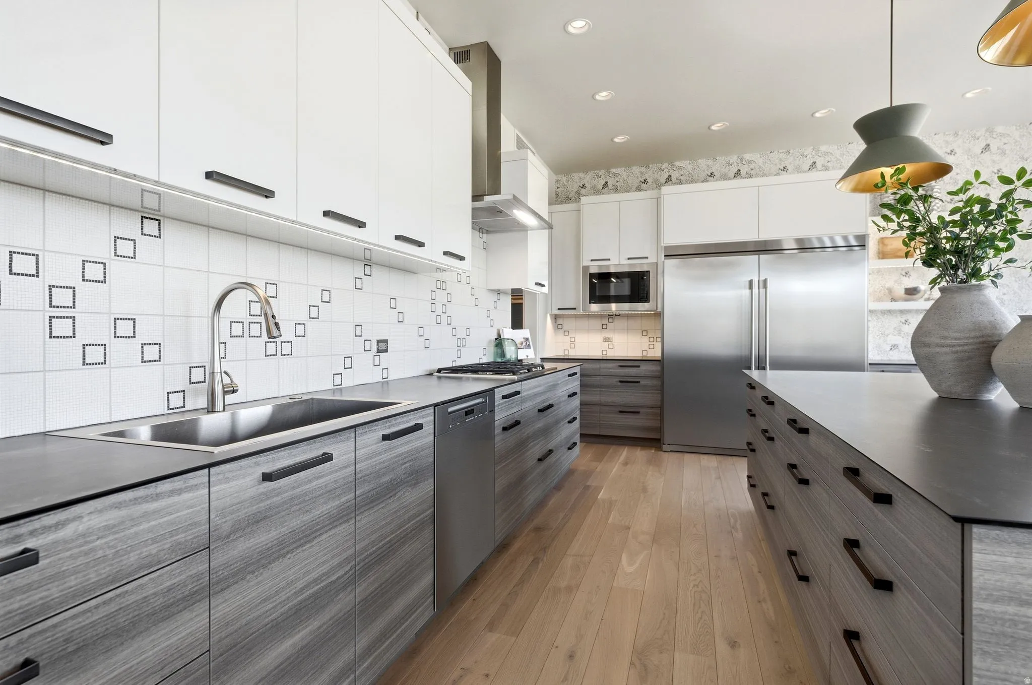 Modern kitchen featuring light wood-finish flooring, white upper cabinetry, and gray wood-grain lower cabinetry