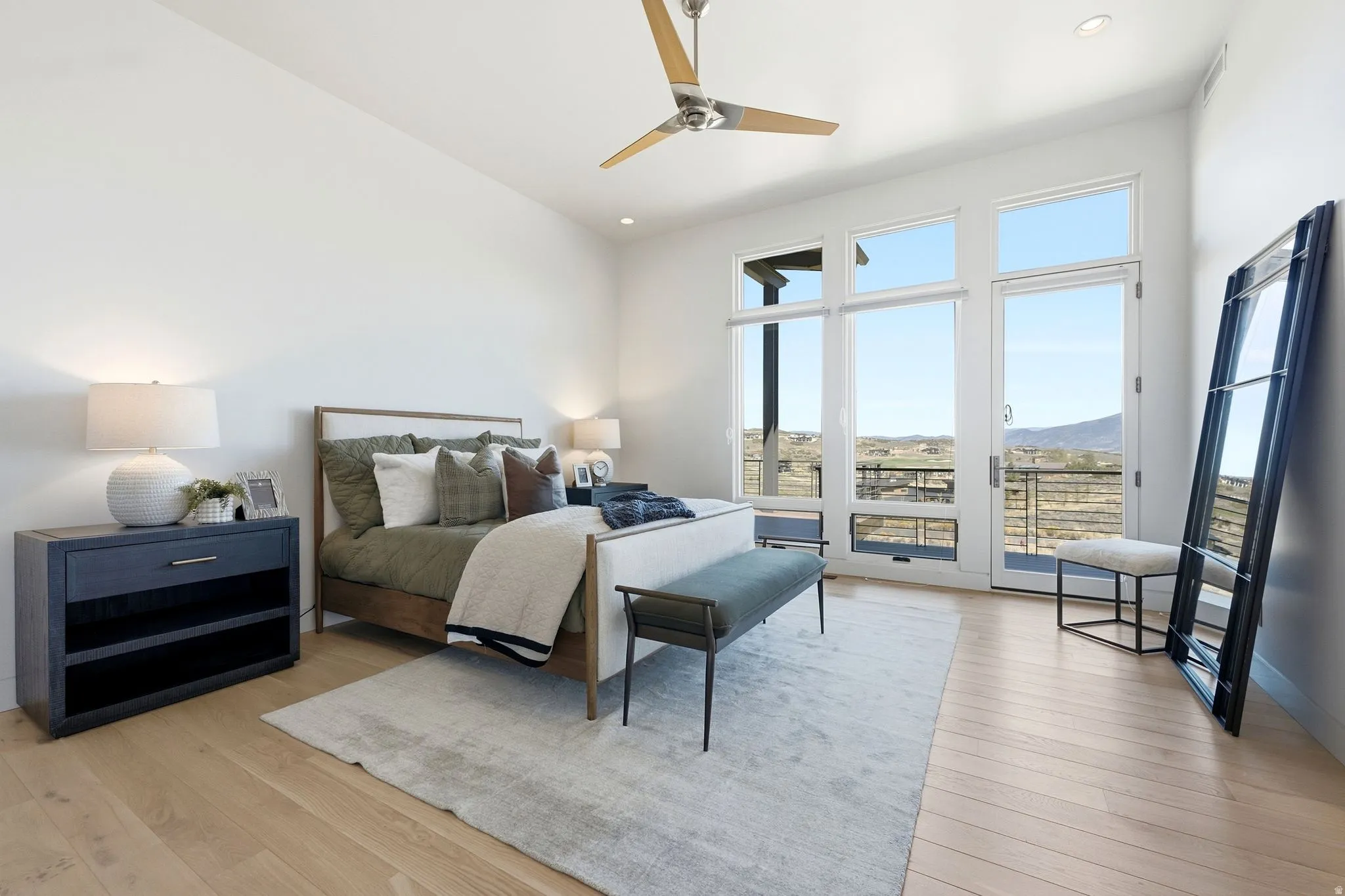 Wood-finish flooring, high ceilings, recessed lighting, and a modern ceiling fan