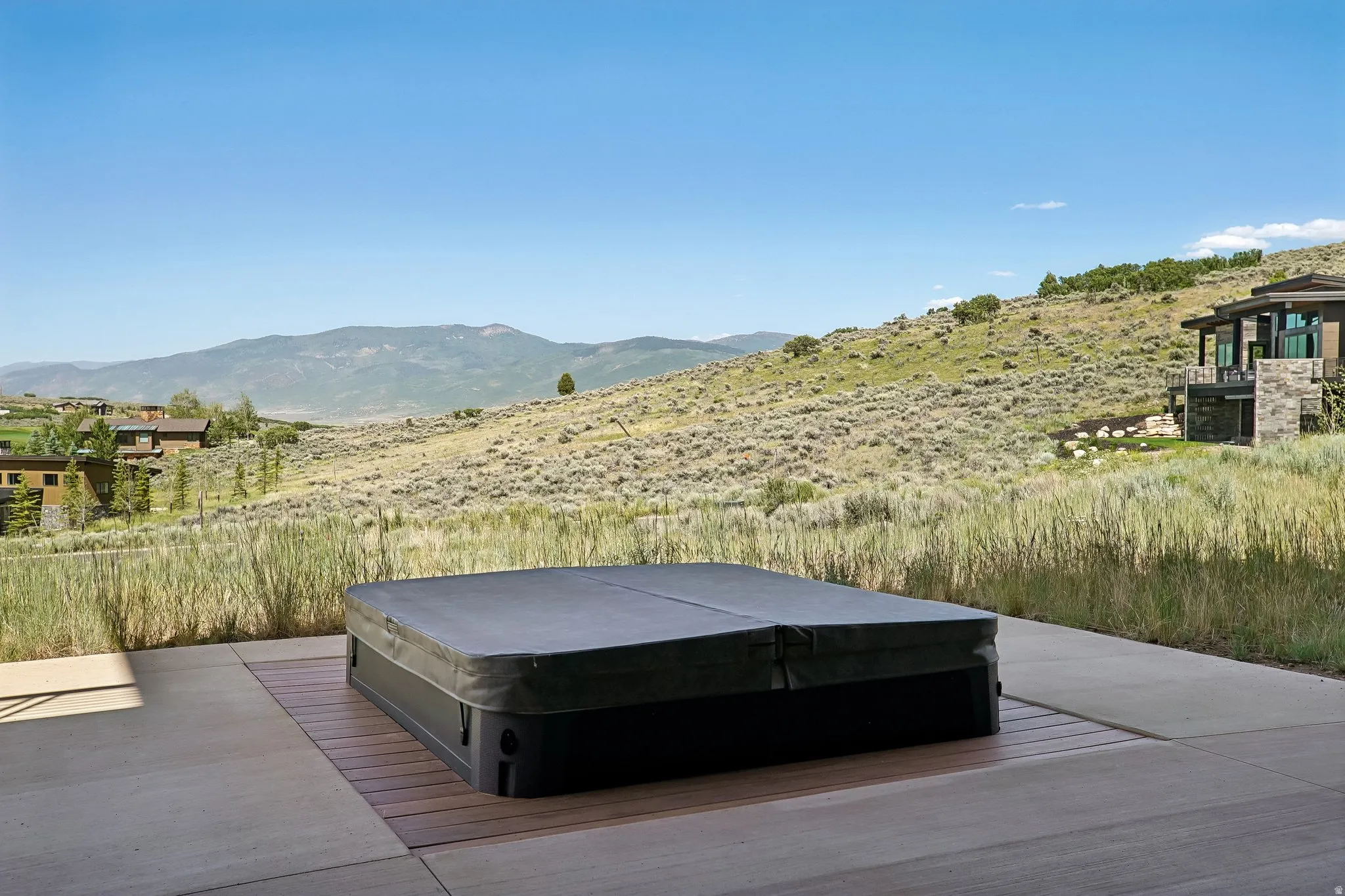 Concrete patio with an integrated hot tub featuring a protective cover