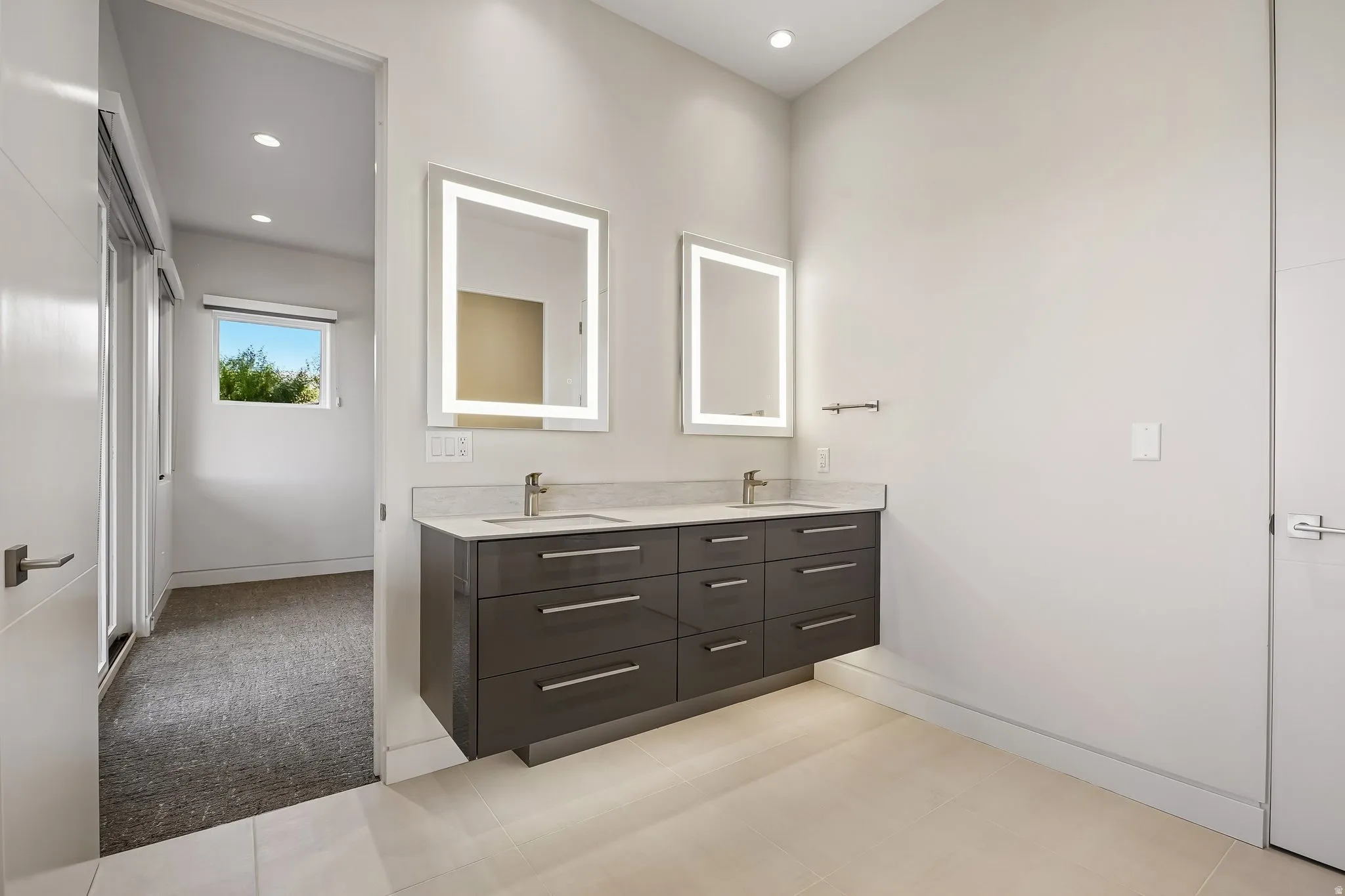 Floating double vanity with a light-toned countertop, two integrated sinks, and contemporary wall-mounted faucets