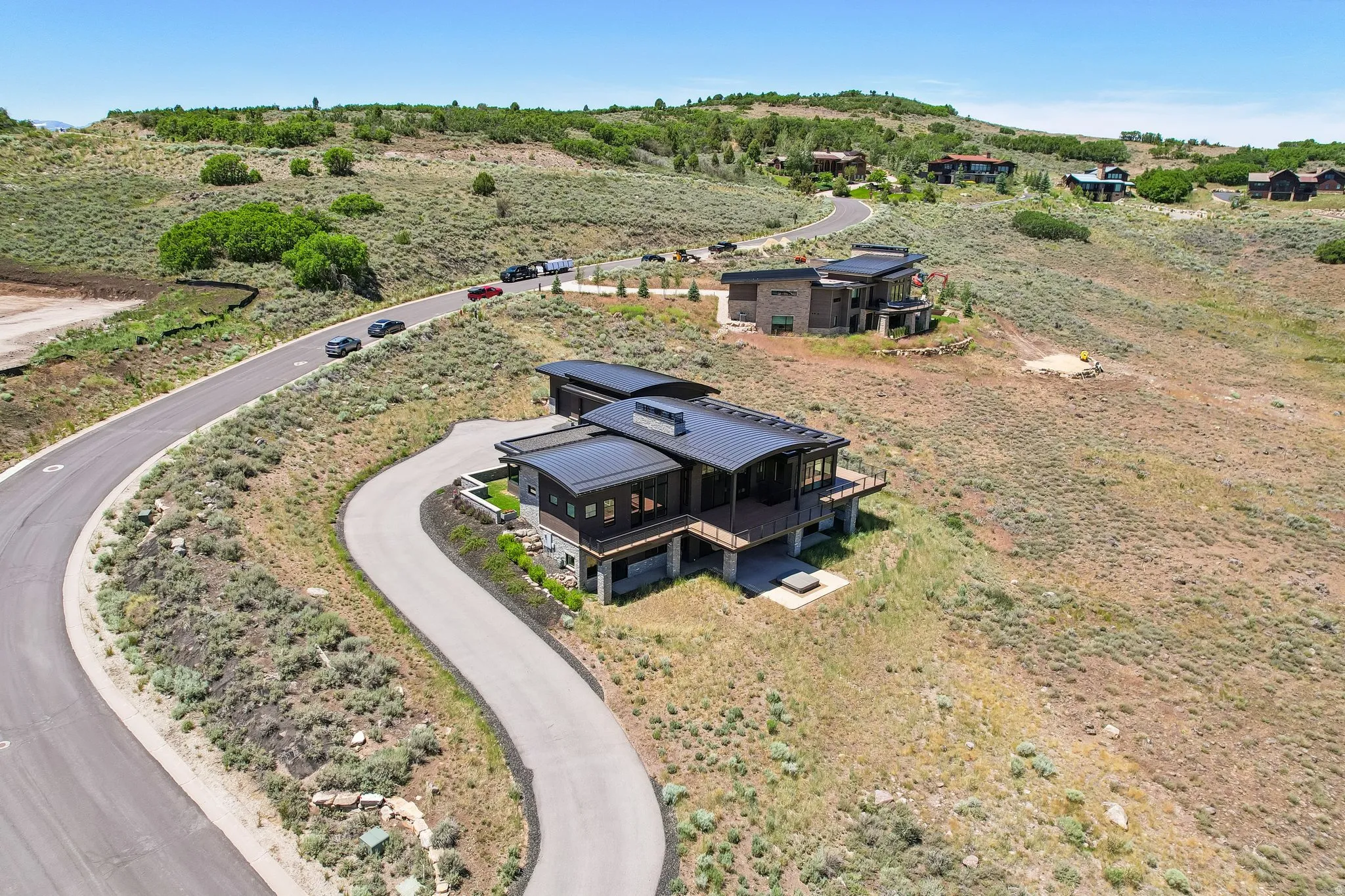 Hillside residence featuring a multi-level design, curved roofline, and expansive deck space