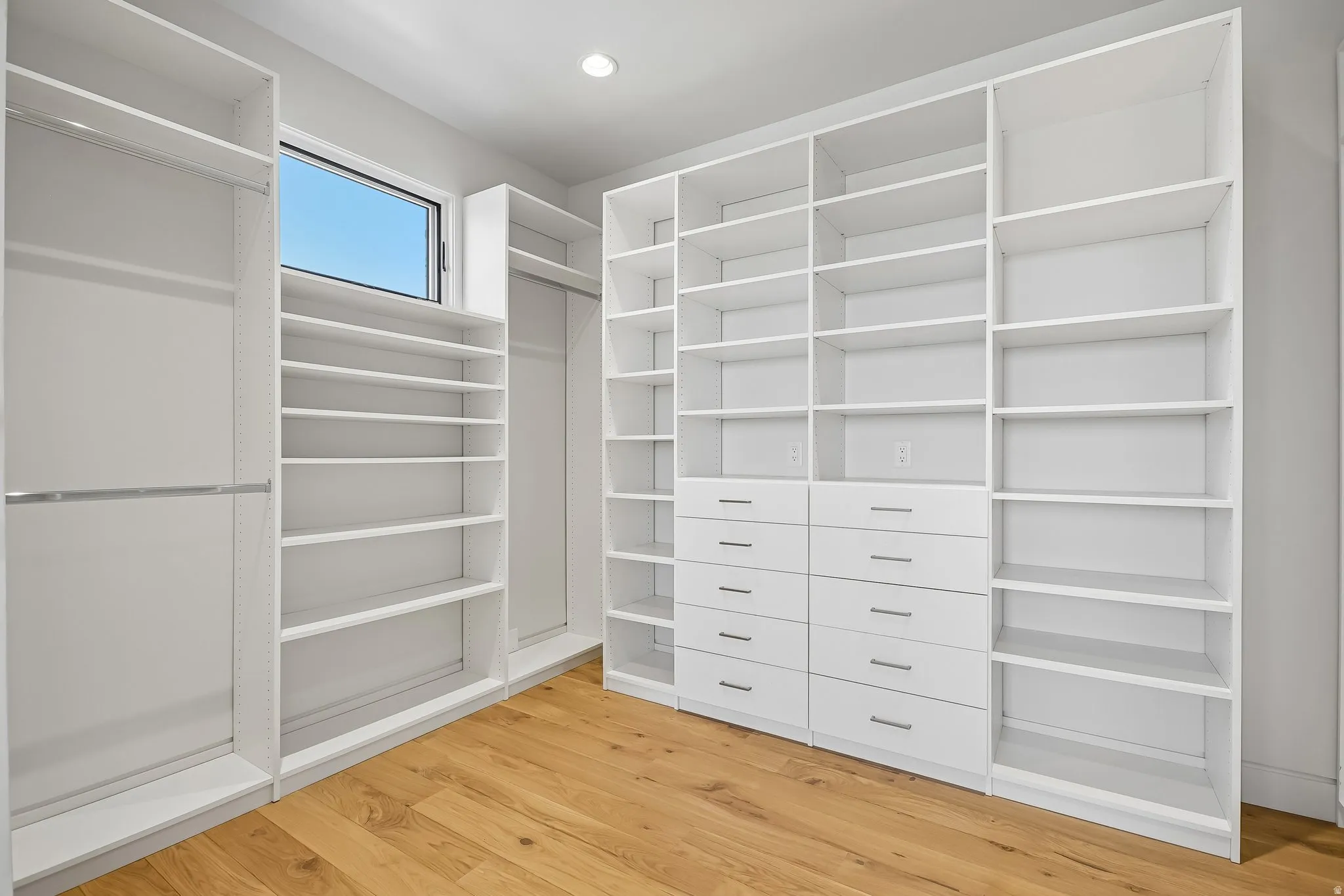 Custom closet system featuring extensive shelving, multiple hanging rods, and built-in drawers