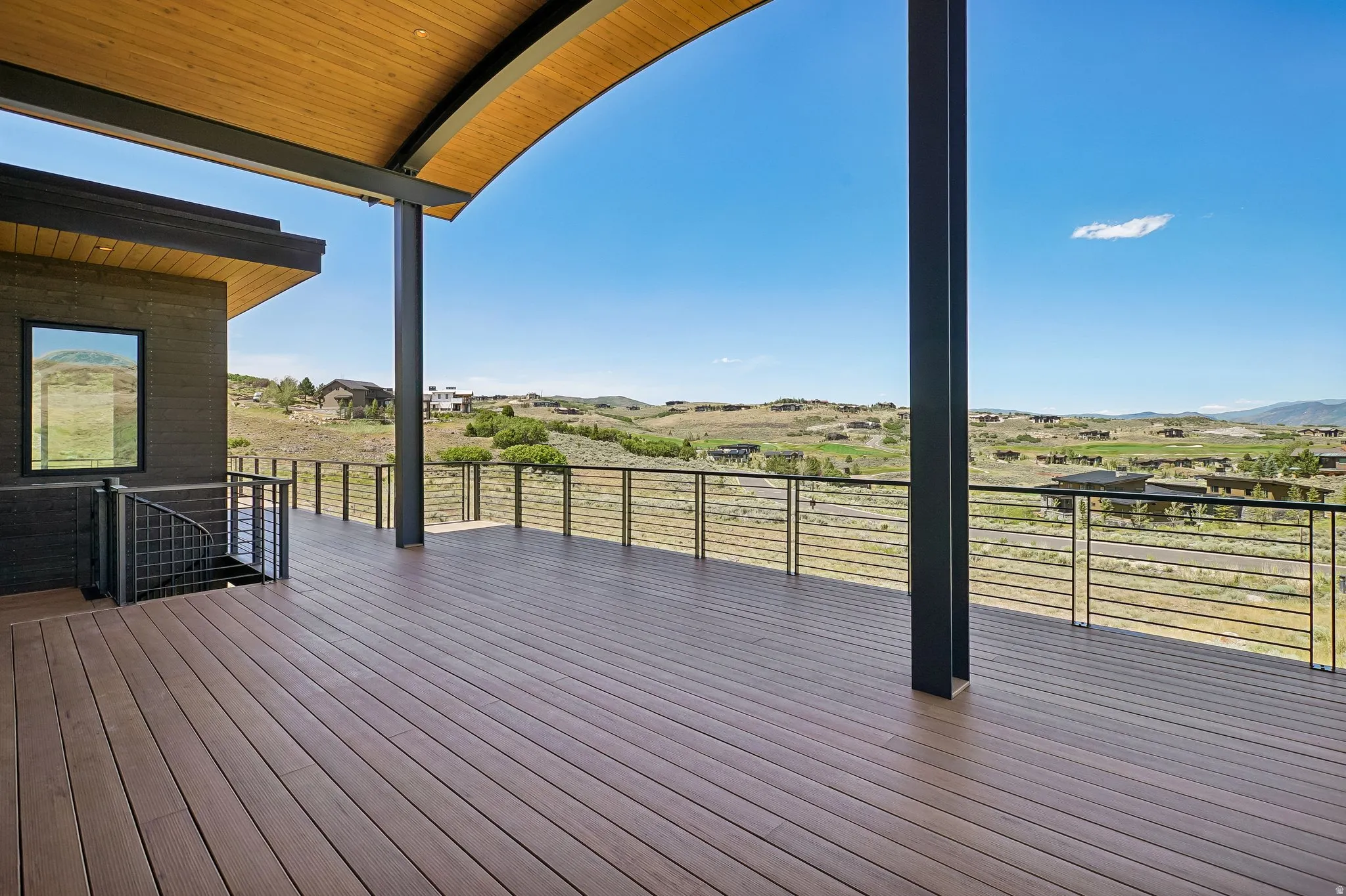 Expansive outdoor deck featuring wood-look flooring and cable railing