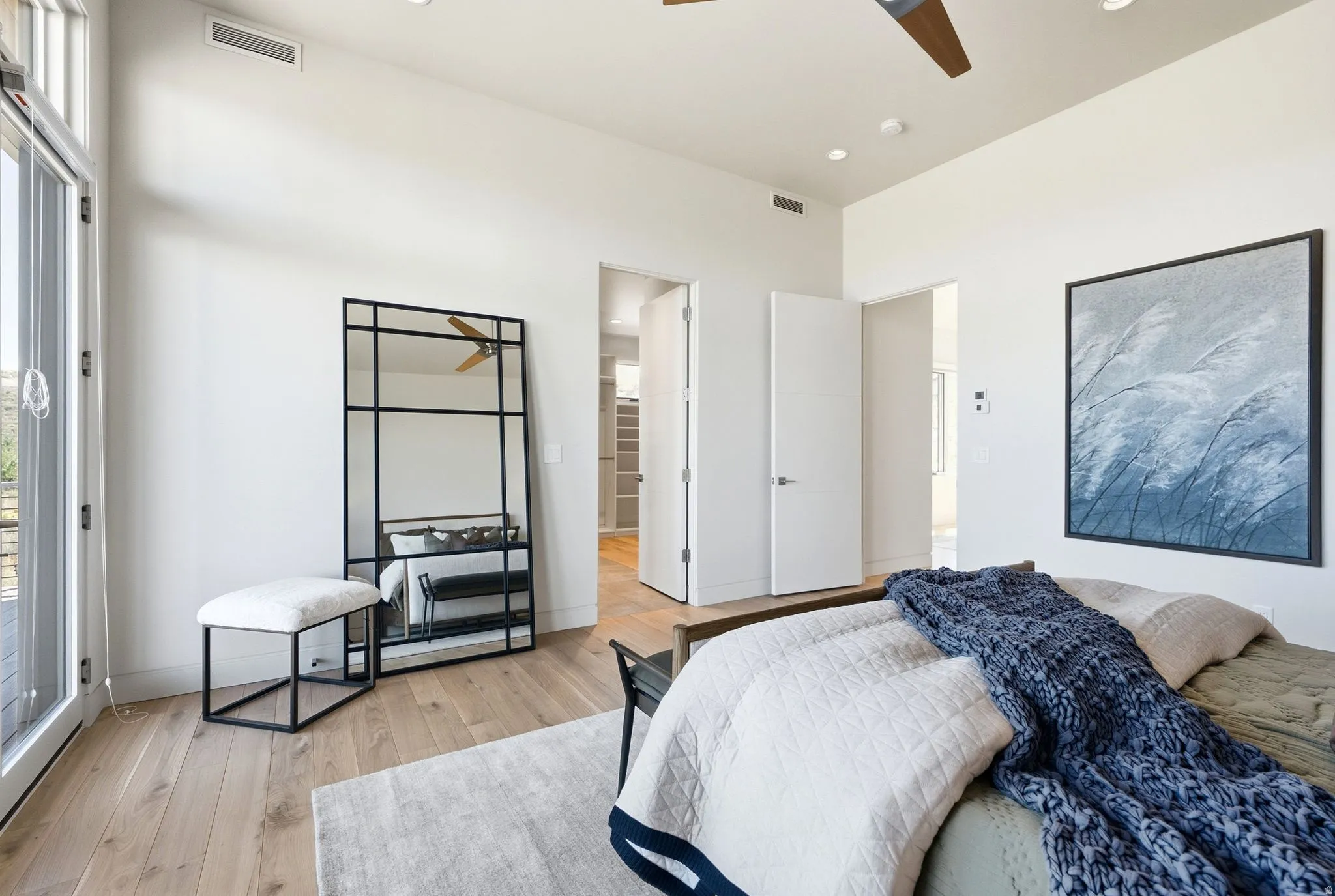 Wood-finish flooring, recessed lighting, ceiling fan, and white doors