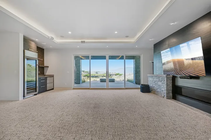 Expansive room featuring sliding glass doors to the exterior, recessed lighting, and tray ceiling