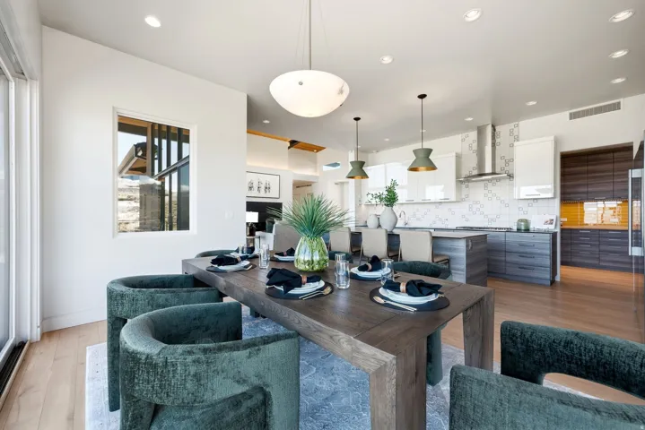 Open-concept dining area with wood-finish flooring, recessed lighting, and a modern chandelier