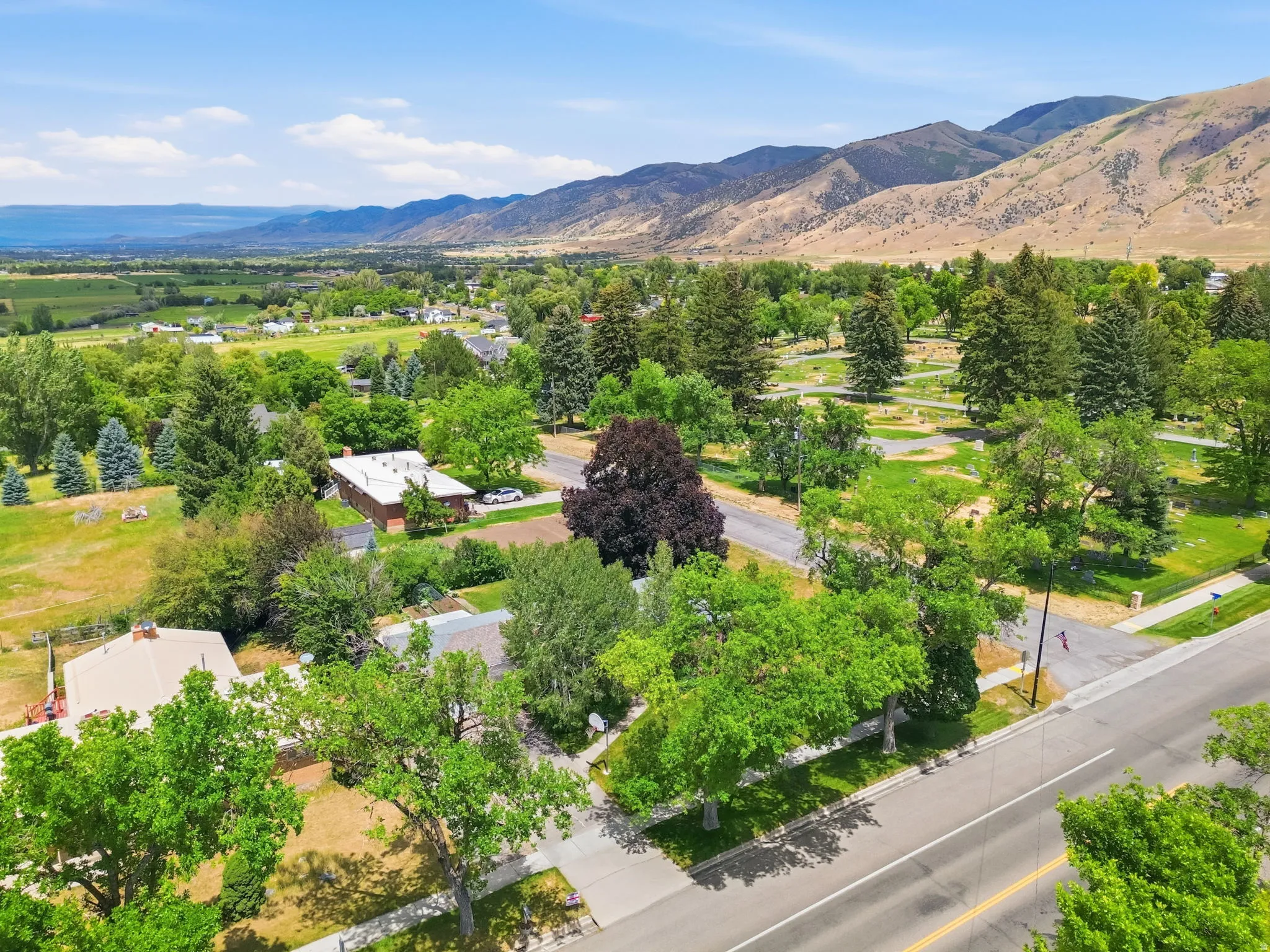 Expansive aerial perspective showcasing broad mountain ranges and a distant body of water