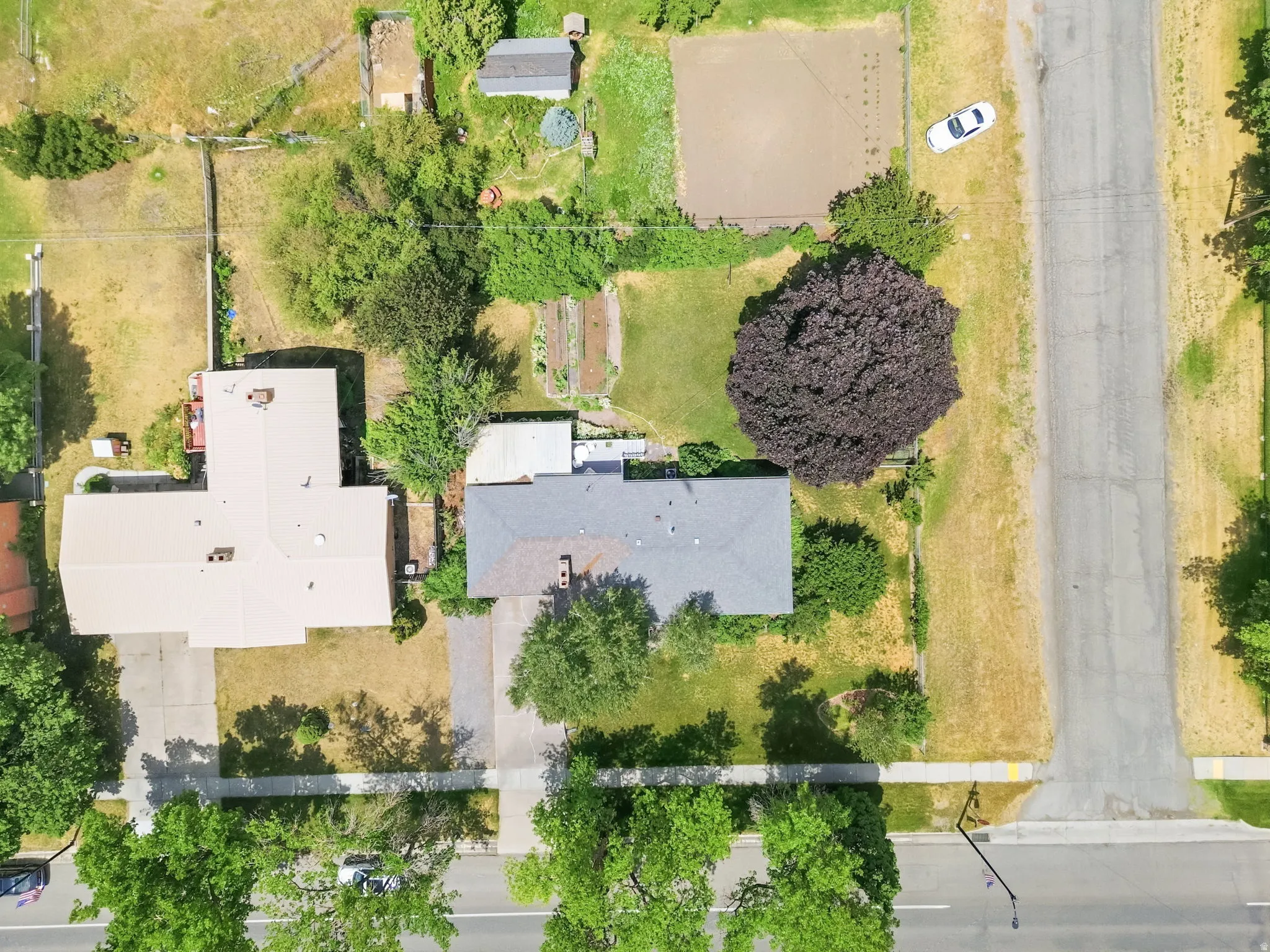 Aerial perspective showcasing the property's expansive lot, mature trees, and detached shed