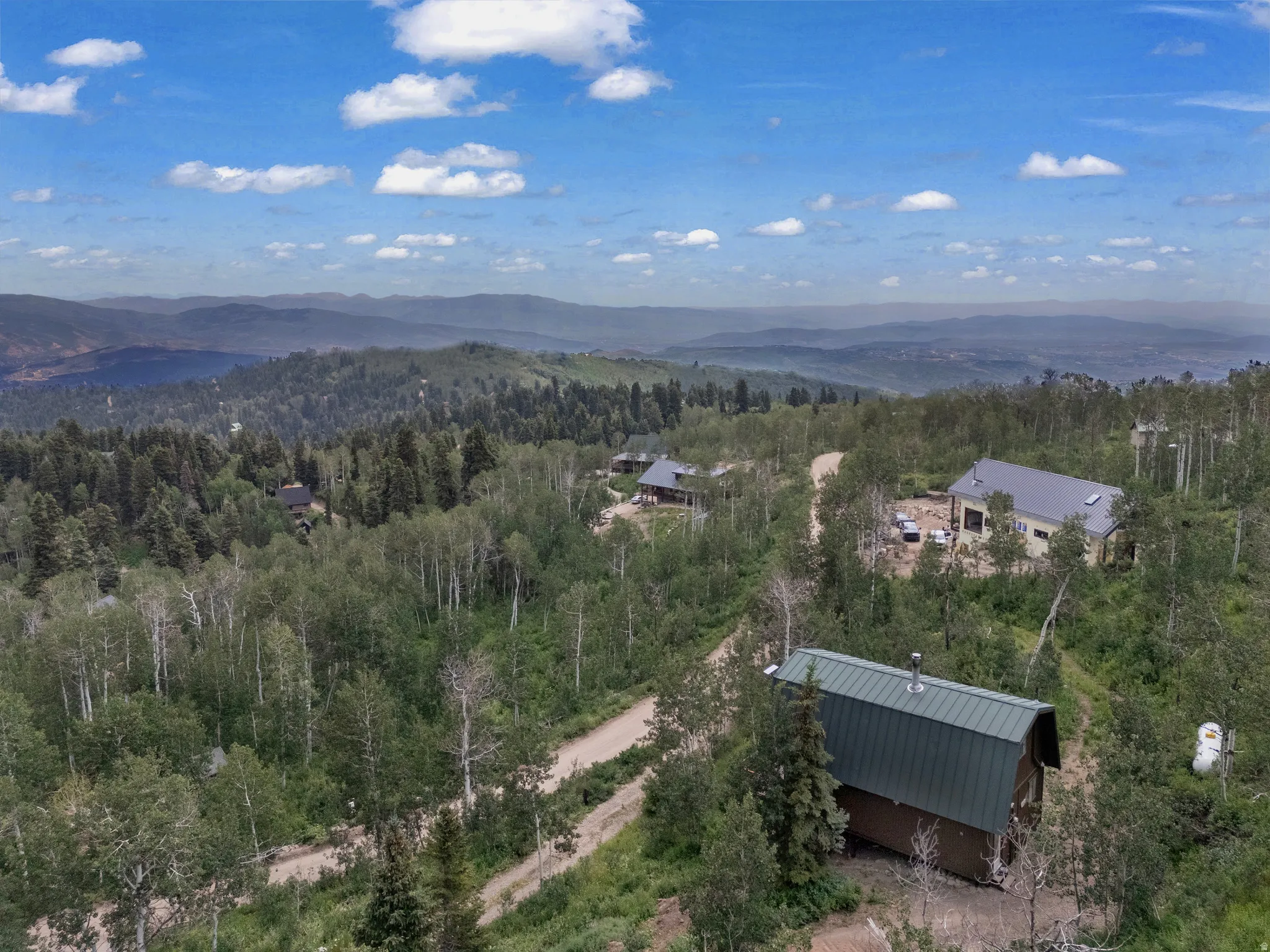 Expansive mountain setting with multiple structures surrounded by dense tree coverage
