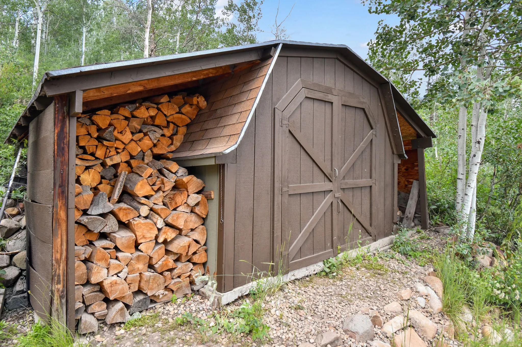 Barn-style shed featuring brown siding and a concrete foundation