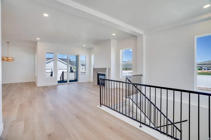 Expansive open-concept living area featuring light wood-finish flooring and recessed lighting throughout