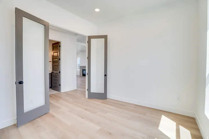 Room featuring light wood-finish flooring, white walls, and recessed lighting