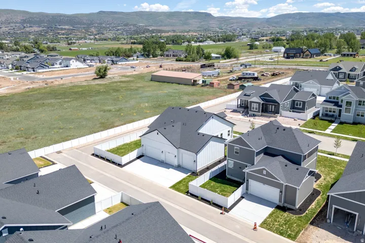 Contemporary residential development featuring multiple two-story homes with dark shingle roofs and light-toned siding