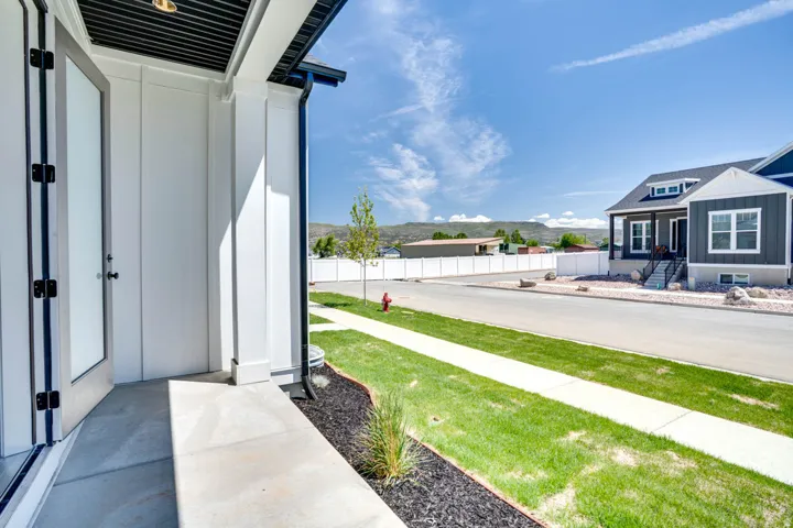 Entryway featuring a double door, covered porch, and white siding