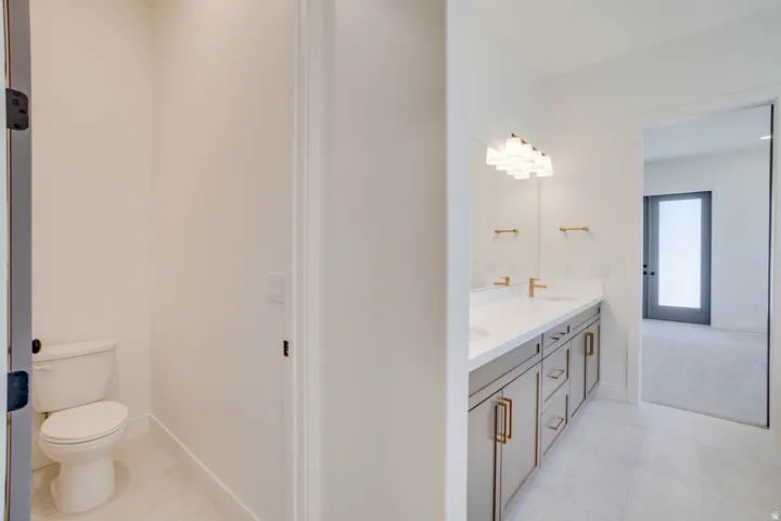 Dual vanity featuring white countertops, undermount sinks, and gold-finish hardware