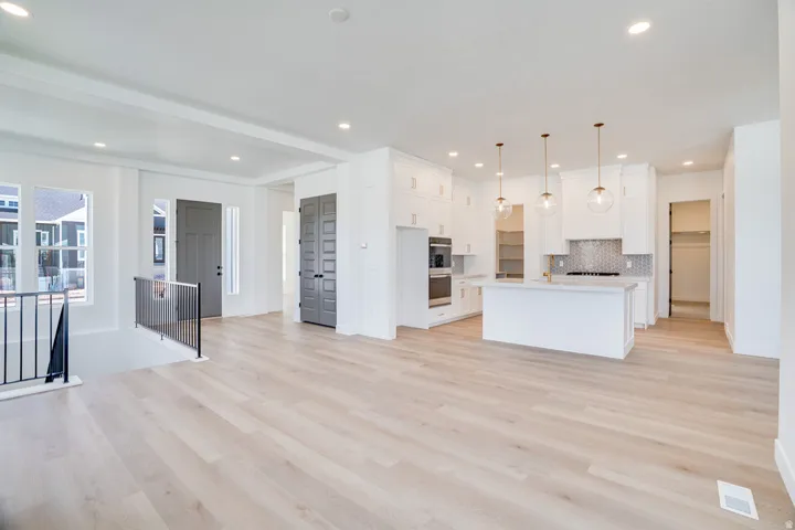 Open-concept living space featuring wood-finish flooring, recessed lighting, and a modern kitchen