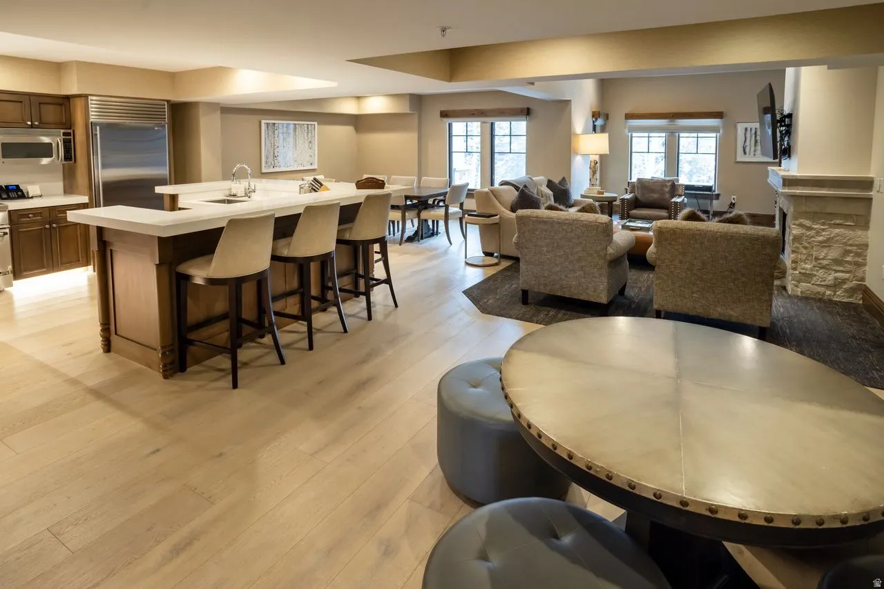 Gourmet kitchen featuring a large island with seating, stainless steel appliances, and wood-finish flooring