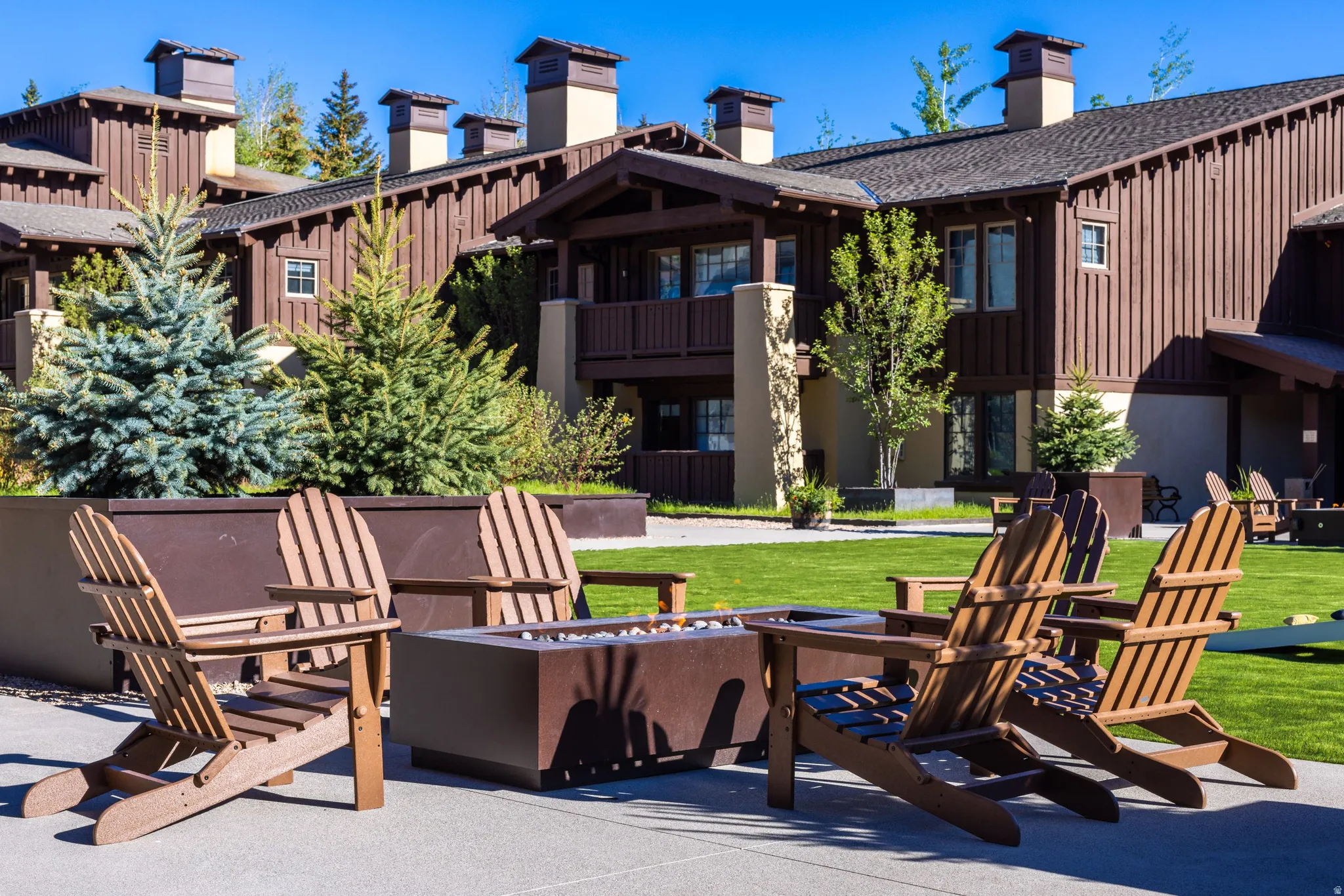 Outdoor patio space featuring a fire pit and Adirondack chairs