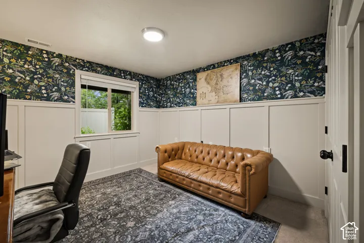 Room featuring wainscoting with a decorative top trim, patterned wallpaper, and a recessed window