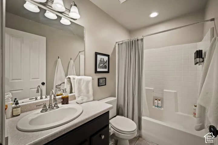 Bathroom featuring a single vanity with an oval sink, brushed nickel faucet, and dark wood-finish cabinetry