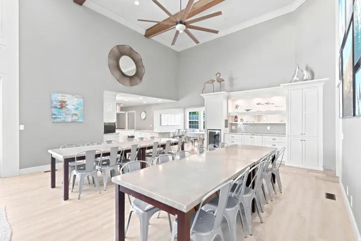 Vaulted ceilings with exposed beams and a large ceiling fan