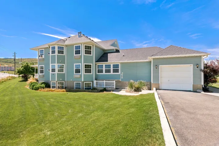 Contemporary multi-level residence featuring light blue siding and multiple bay windows
