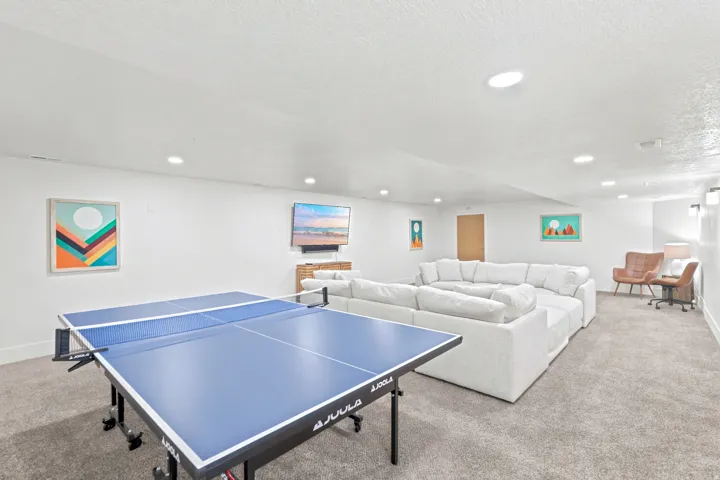 Spacious entertainment area featuring recessed lighting, light-toned carpeting, and white painted walls