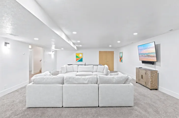 Spacious room featuring light gray carpeting and white walls