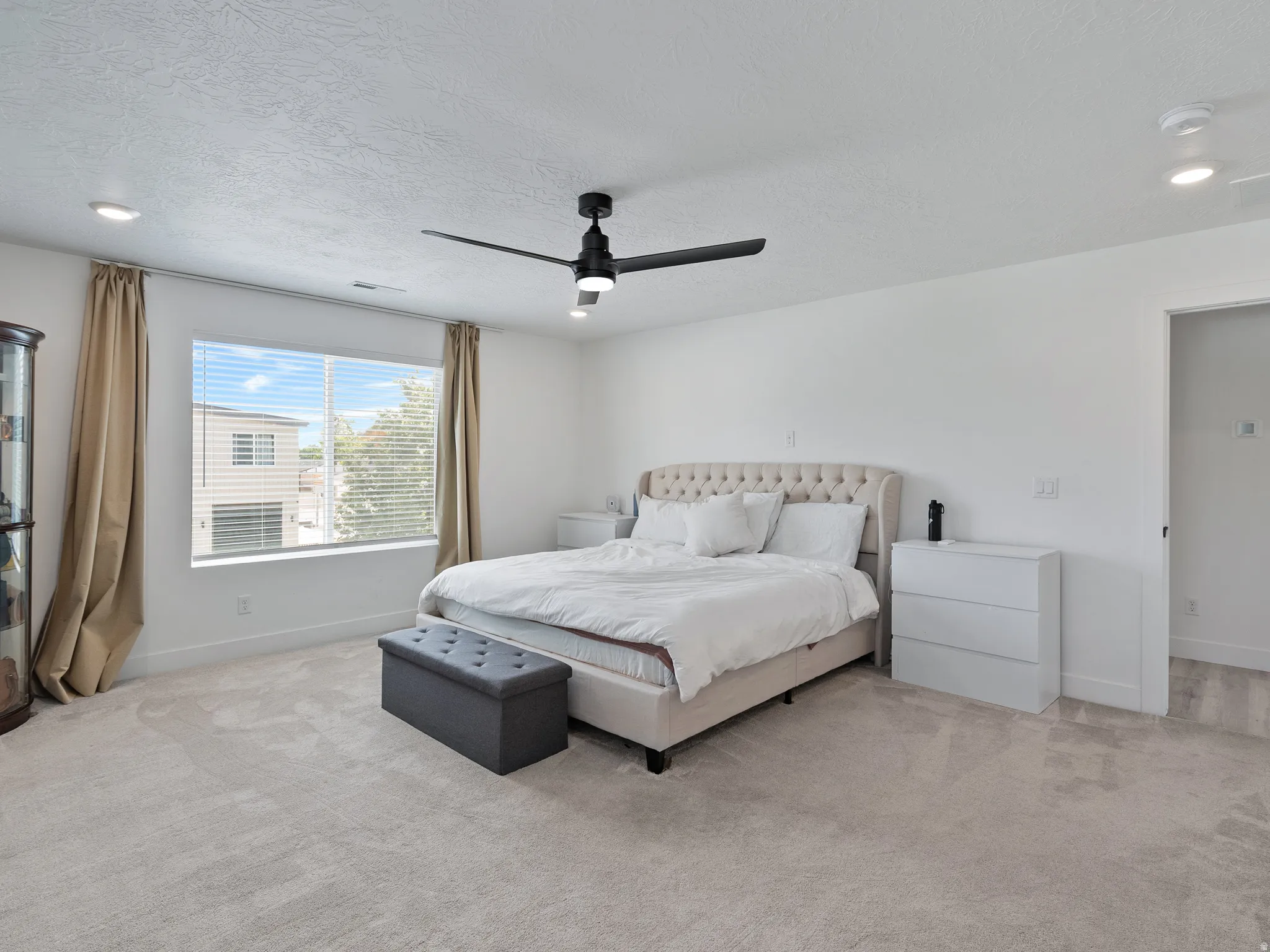 Spacious room featuring light-colored carpeting, recessed lighting, and a contemporary ceiling fan