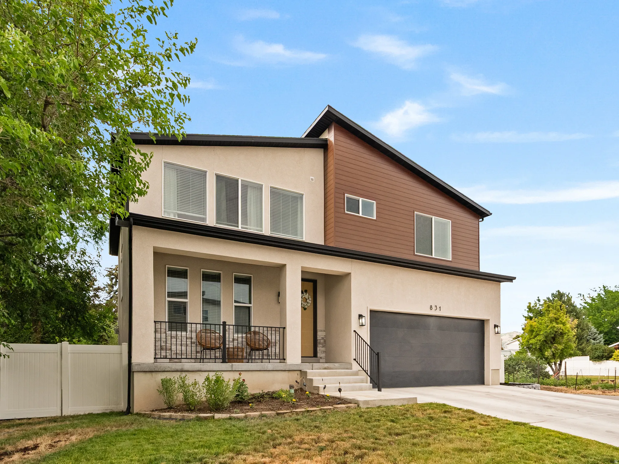 Modern architectural exterior featuring beige stucco and wood-look siding accents