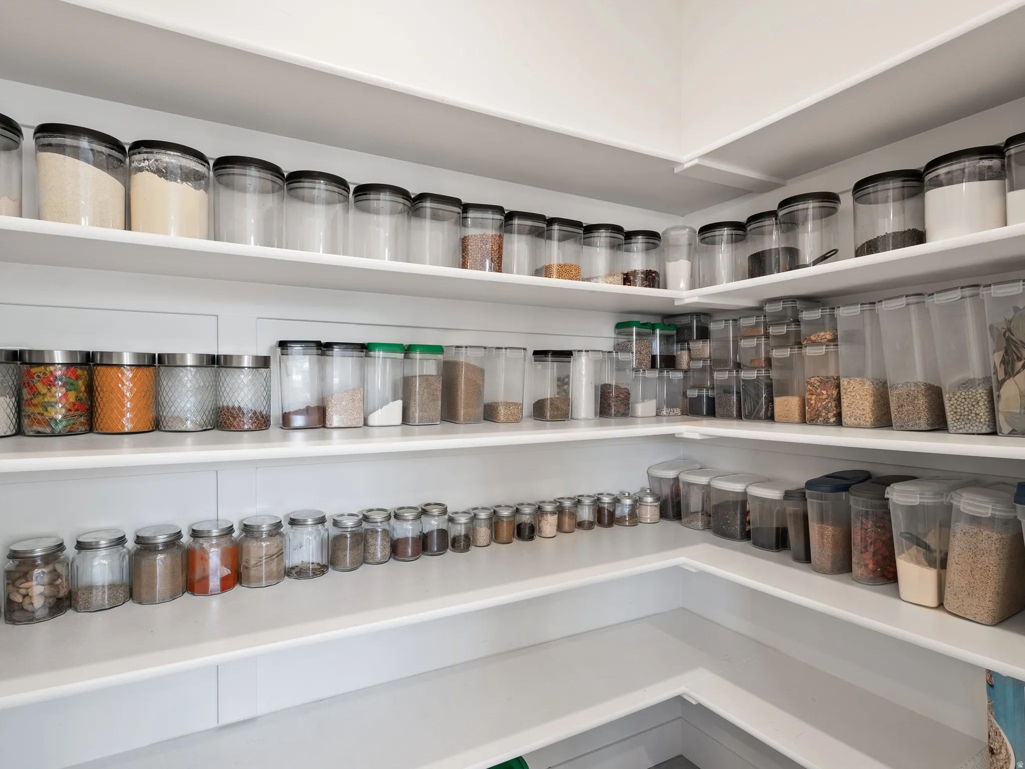 Corner pantry with multiple levels of white shelving
