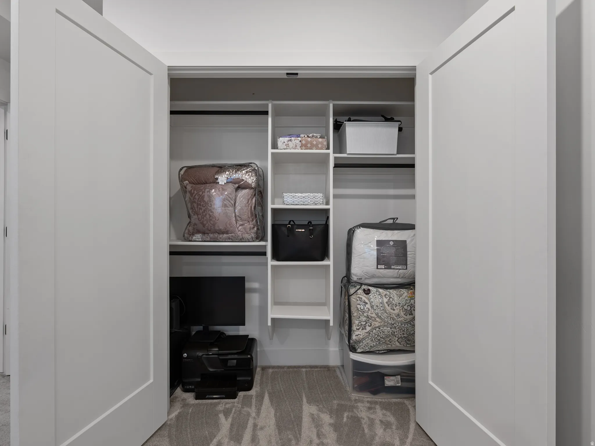Closet with white double doors, featuring integrated shelving and hanging rods