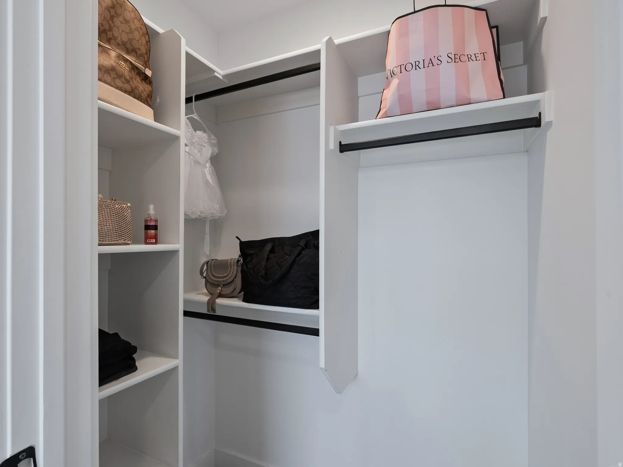 Built-in white shelving and hanging rods create a versatile storage solution