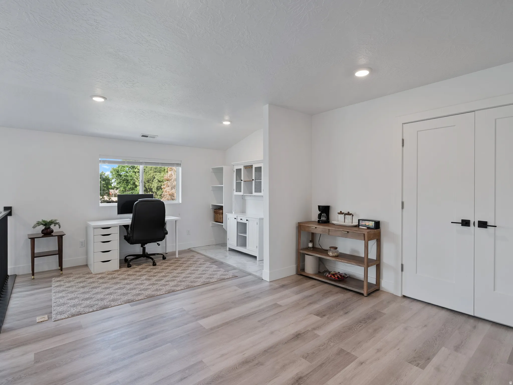 Open-concept space featuring light wood-finish flooring and recessed lighting