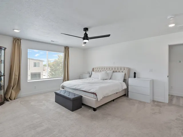 Spacious room featuring light-colored carpeting, recessed lighting, and a contemporary ceiling fan