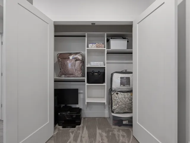 Closet with white double doors, featuring integrated shelving and hanging rods