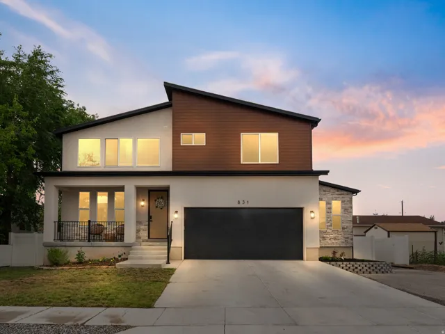 Modern facade featuring a combination of light stucco, brown wood-finish siding, and stone accents