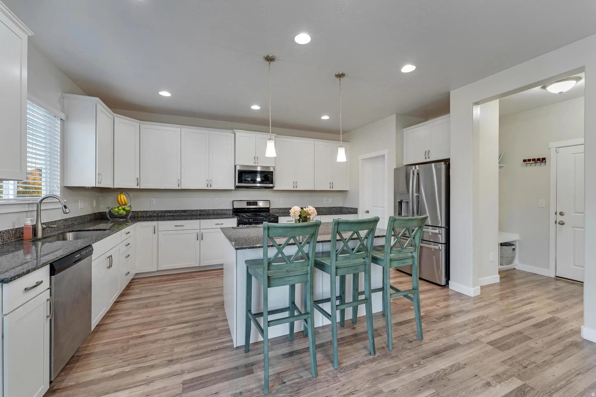 Modern kitchen featuring white cabinetry, dark countertops, and stainless steel appliances