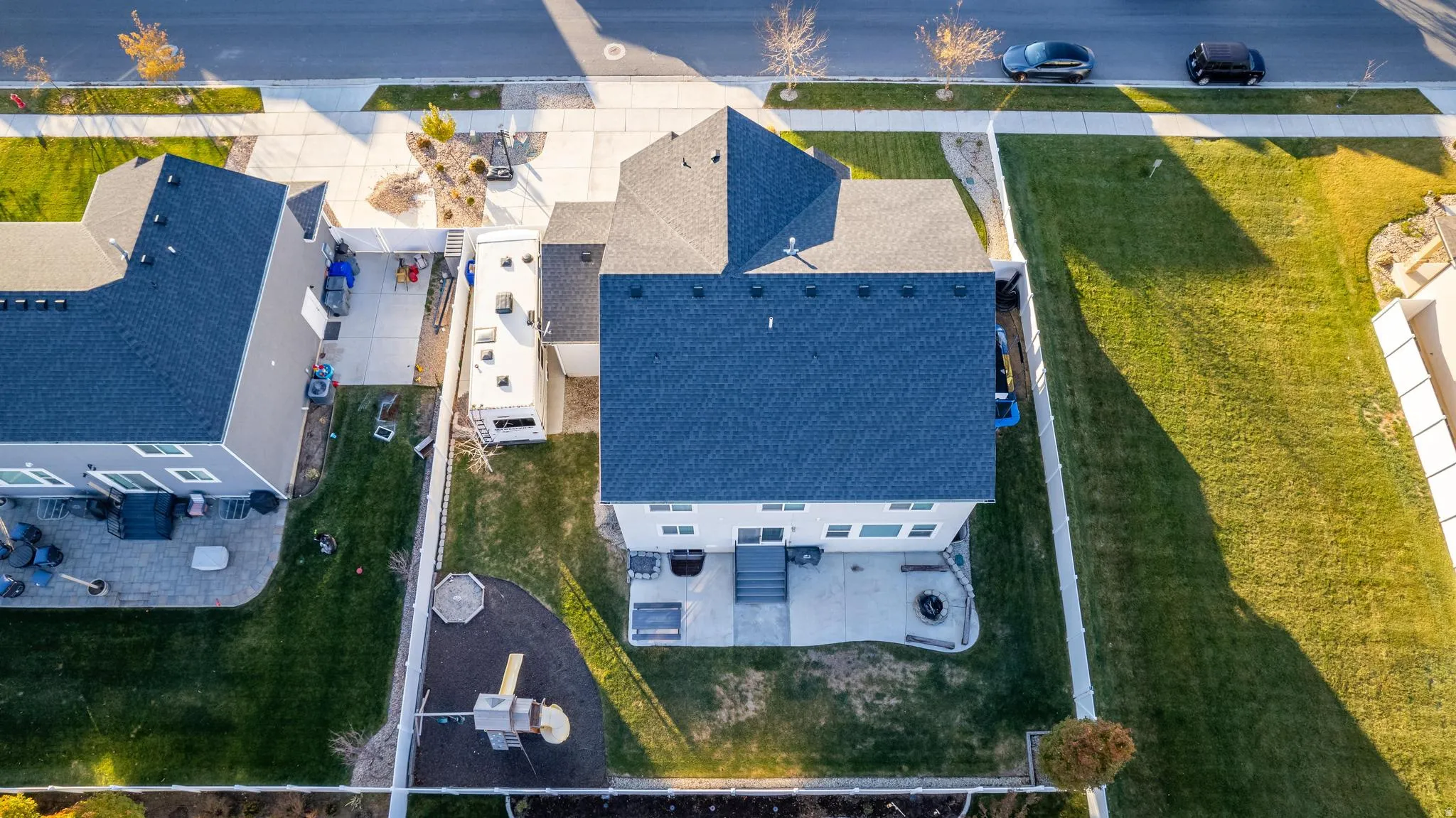 Aerial view of a residential property featuring a dark shingle roof and light-colored siding