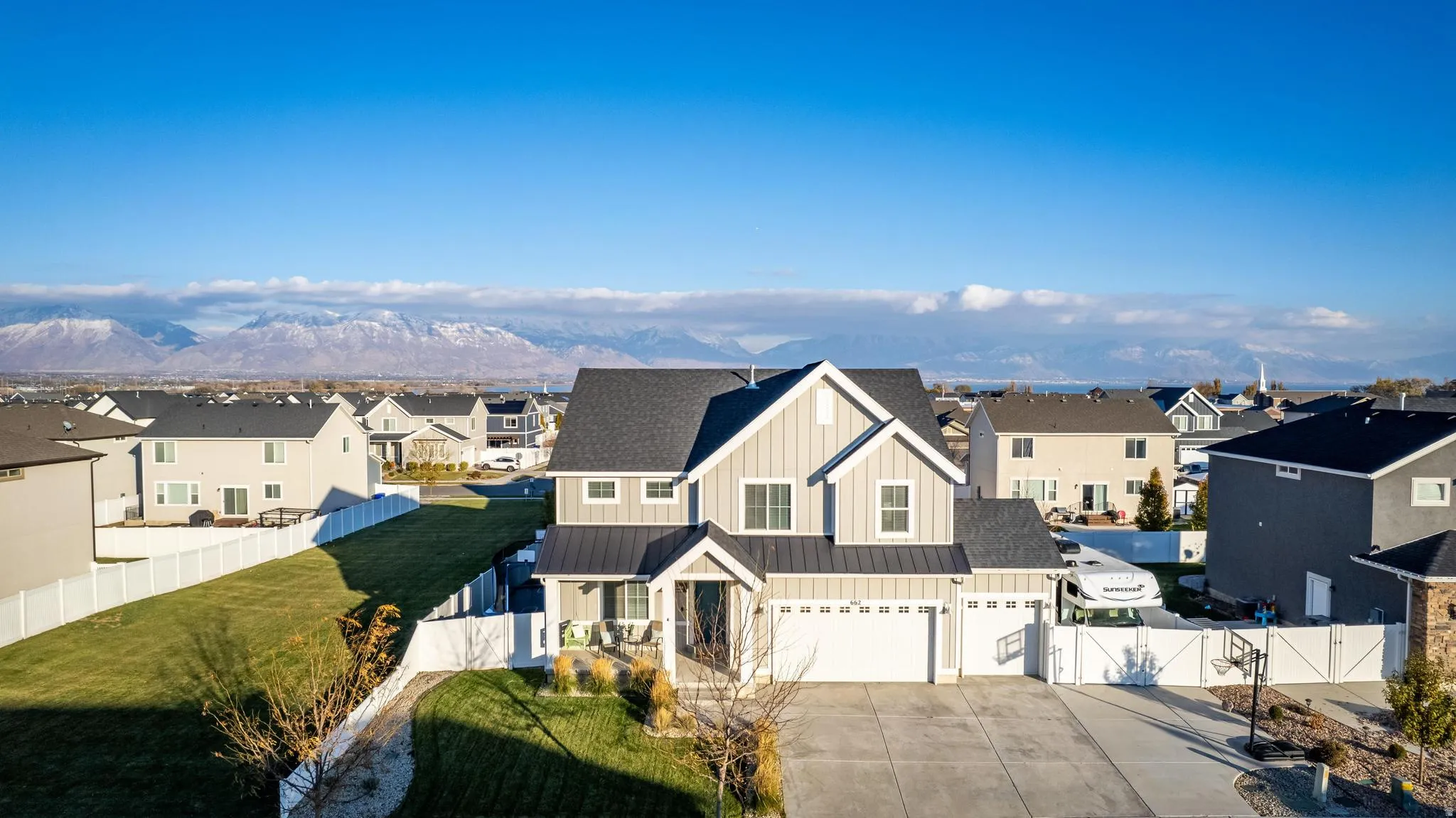 Contemporary two-story residence featuring light gray vertical siding and dark gray roofing