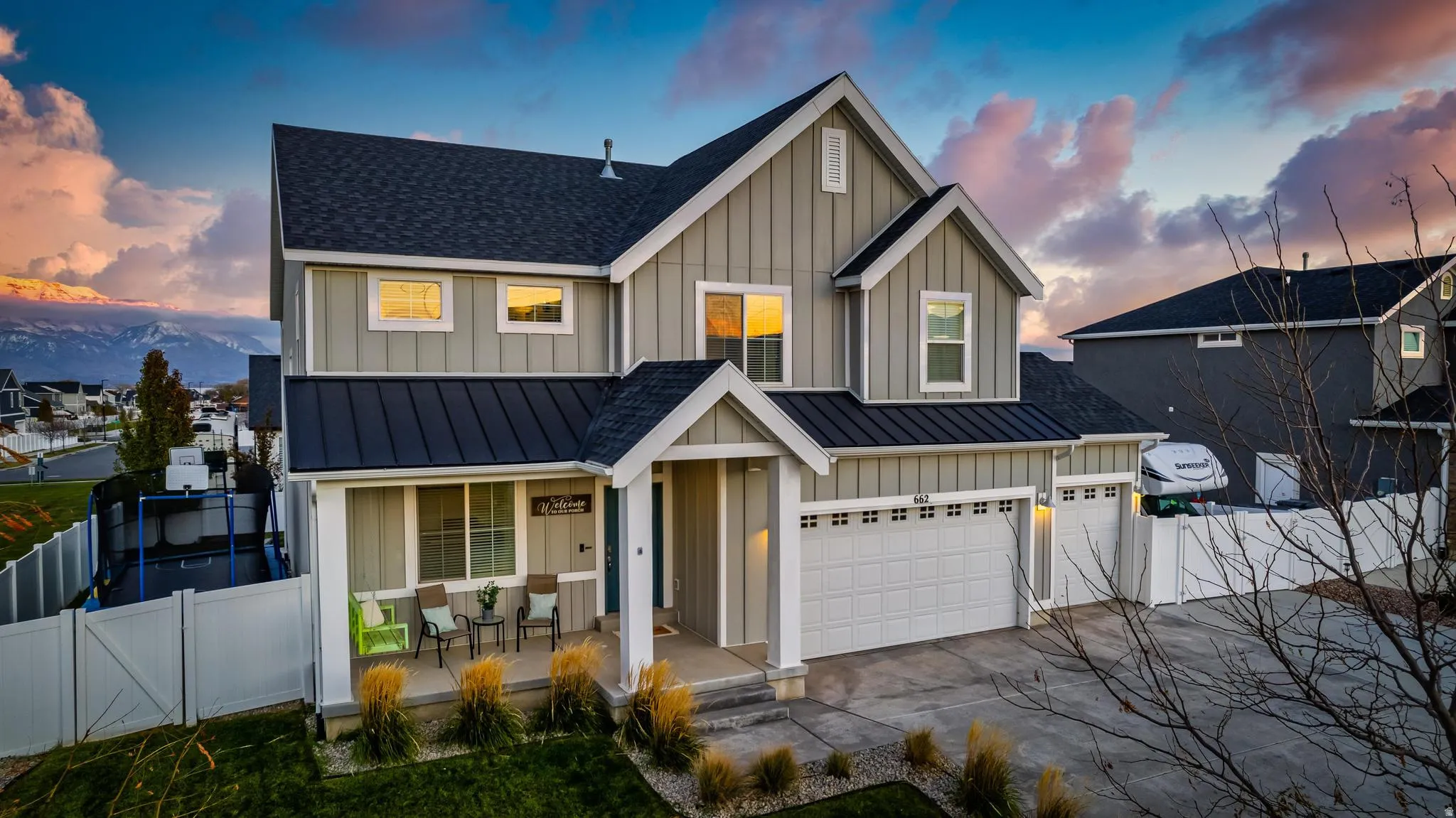 Modern two-story residence featuring light gray board-and-batten siding with white trim accents