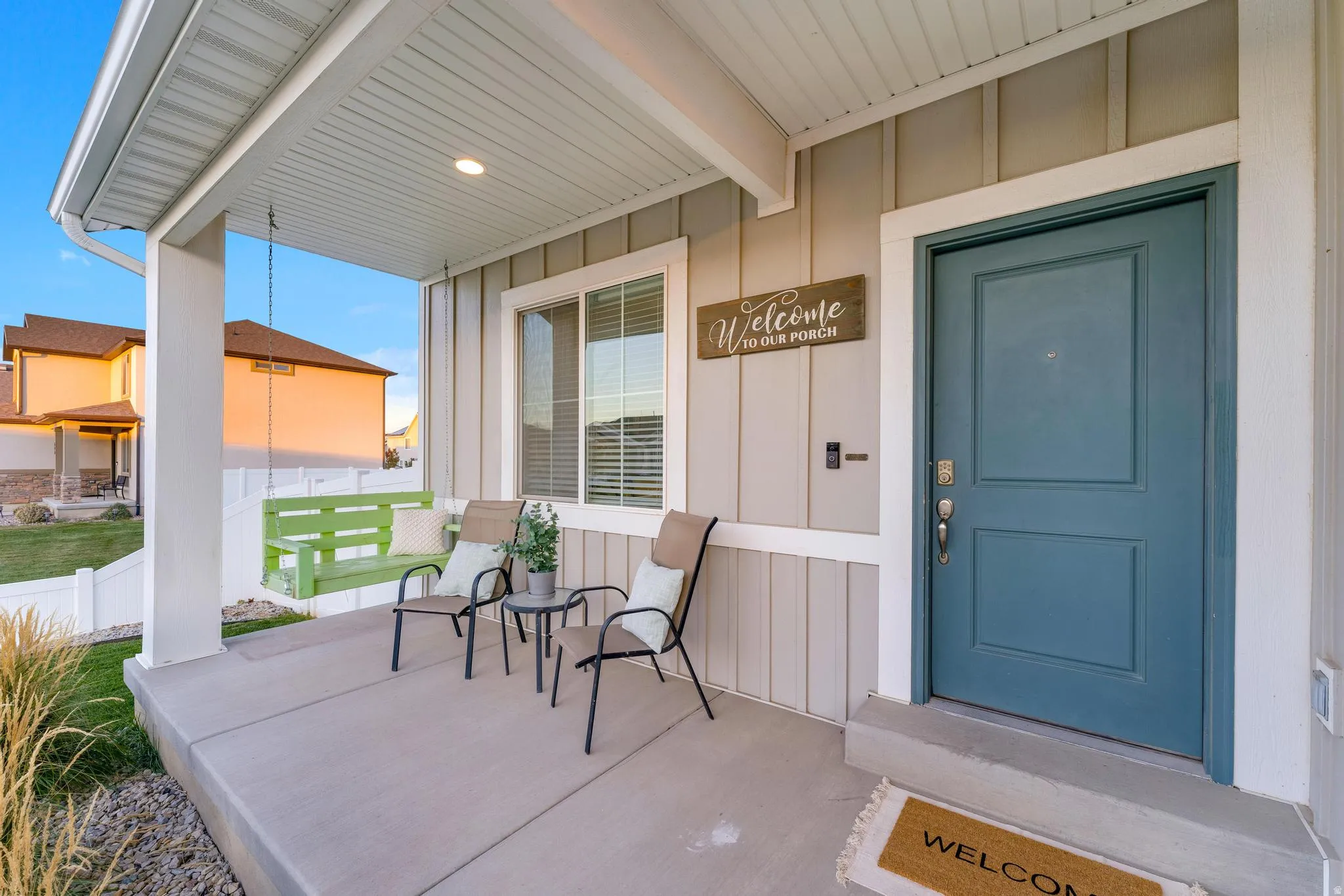 Covered front porch with concrete flooring and vertical siding