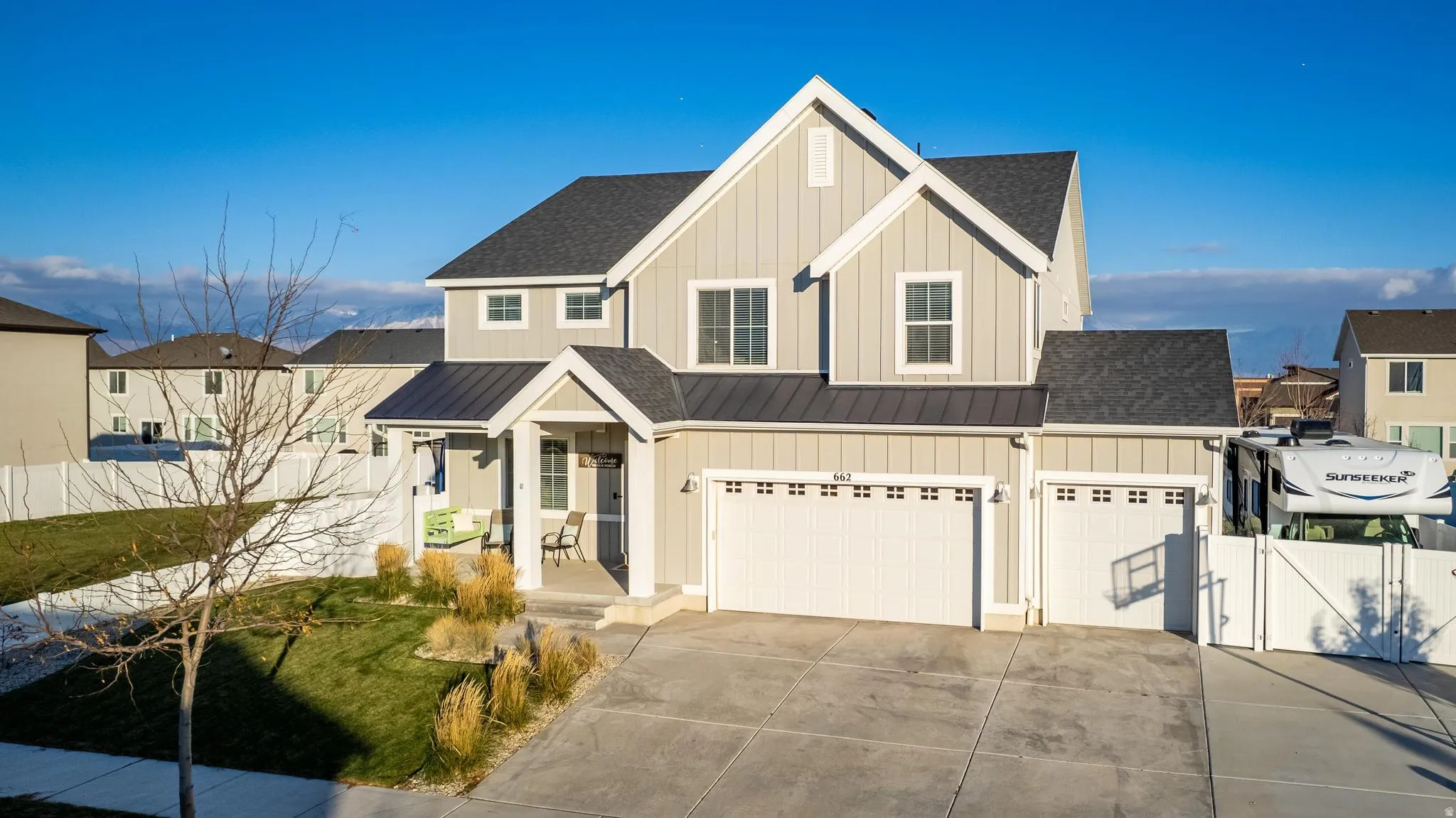 Contemporary two-story residence featuring light gray siding and a dark shingled roof