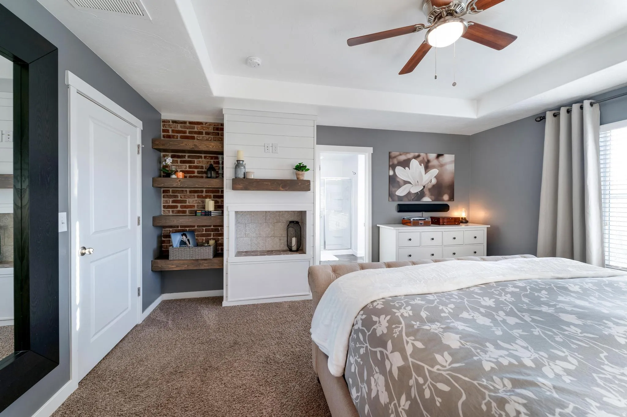 Bedroom featuring tray ceiling, ceiling fan, and carpeted flooring